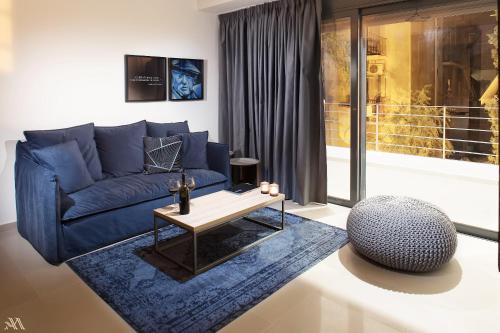 a living room with a blue couch and a table at Elysium Boutique Apartments in Athens