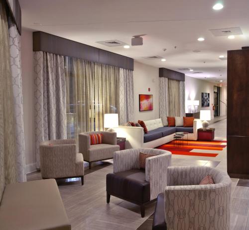 Holiday Inn Charlotte Airport, an IHG Hotel في تشارلوت: غرفة معيشة مع كنب وكراسي