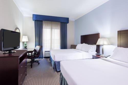 a hotel room with two beds and a flat screen tv at Holiday Inn Express Hotel & Suites New Iberia - Avery Island by IHG in New Iberia