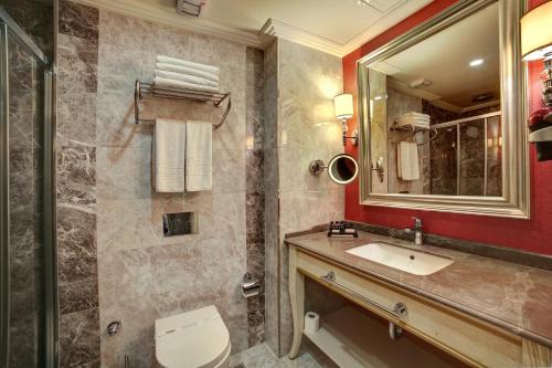a bathroom with a sink and a toilet and a mirror at Halifaks Hotel in Istanbul
