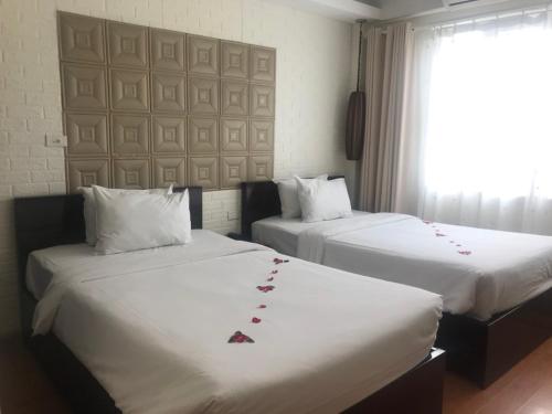 Łóżko lub łóżka w pokoju w obiekcie Hanoi Impressive Hotel