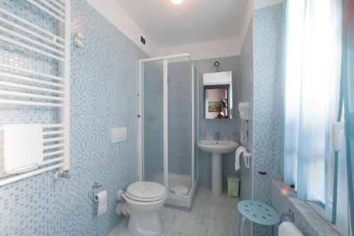 uma casa de banho em azulejos azuis com um WC e um lavatório em Hotel Tirreno em Gênova