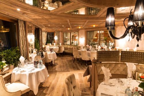 restauracja z białymi stołami i krzesłami oraz sufitem w obiekcie Stock Resort w mieście Finkenberg