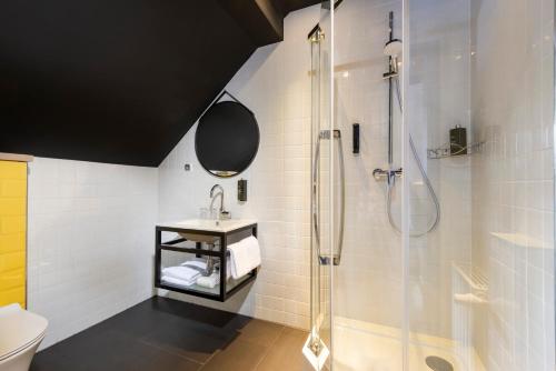 uma casa de banho com uma cabina de duche em vidro e um lavatório. em ibis Styles Dresden Neustadt em Dresden