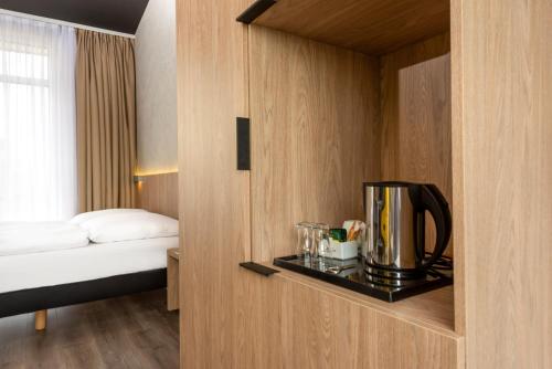 a hotel room with a coffee maker on a shelf at ibis Styles Dresden Neustadt in Dresden
