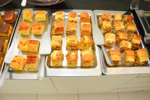 a buffet filled with different types of food on trays at Tapajos Palace Hotel in Novo Progresso