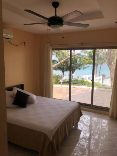 a bedroom with a bed and a ceiling fan at Amami Beachfront Villa with Private Beach in Puerto Galera