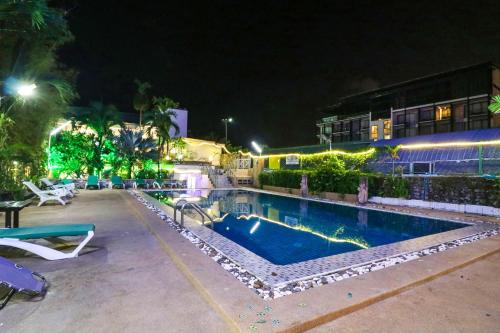 a swimming pool in front of a building at night at Natural Beach Hotel Pattaya in Pattaya Central