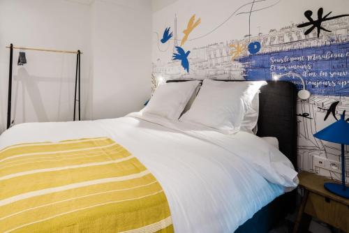 um quarto com uma grande cama branca e um cobertor amarelo em SUITE APOLLINAIRE : au cœur de la Rive Gauche, neuf, design, 2/4 personnes em Paris