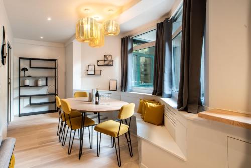 ein Esszimmer mit einem Tisch, Stühlen und einem Fenster in der Unterkunft SUITE APOLLINAIRE : au cœur de la Rive Gauche, neuf, design, 2/4 personnes in Paris