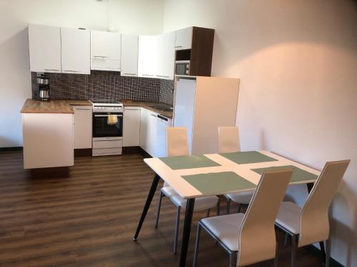a kitchen with a table and chairs and white cabinets at Jakobstad Pietarsaari city center apartment 55m2 in Pietarsaari