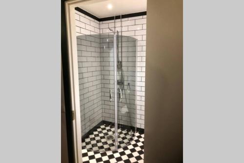 a shower with a black and white checkered floor at Jakobstad Pietarsaari city center apartment 55m2 in Pietarsaari