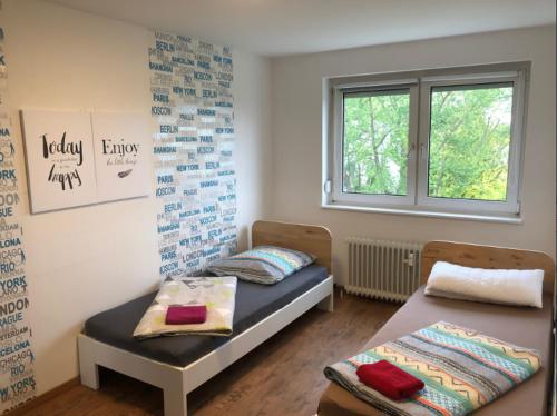 Zimmer mit 2 Betten und einem Fenster in der Unterkunft Ferienwohnung Mainz Stadt in Mainz
