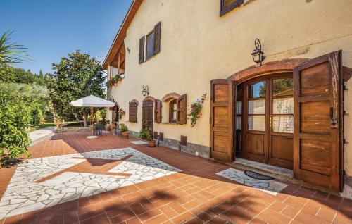 a house with wooden doors and a brick courtyard at Agriturismo Mannaioni in Volterra
