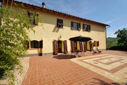 a house with a patio with a table and an umbrella at Agriturismo Mannaioni in Volterra