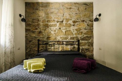 ein Schlafzimmer mit einem Bett mit einer Steinmauer in der Unterkunft Accogliente Bussana 1 in Sanremo