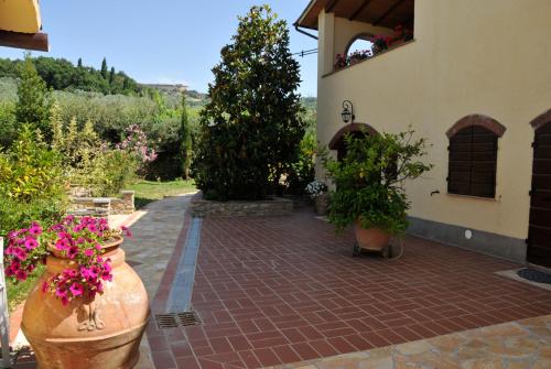 a garden with flowers in large vases next to a building at Agriturismo Mannaioni in Volterra