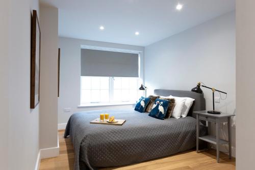 a bedroom with a bed with a tray on it at Hampden Apartments - The Diana in Windsor