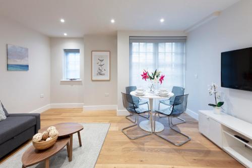 a living room with a table and a tv at Hampden Apartments - The Diana in Windsor