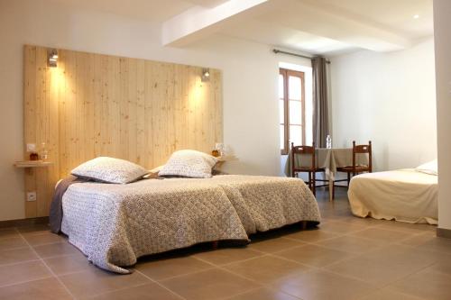 Les Chambres du Moulin a Huile في فيسون-لا-رومان: غرفة نوم عليها سرير ووسادتين