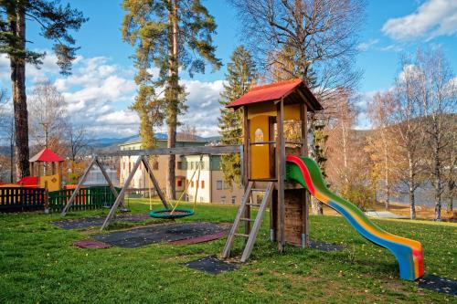 einen Spielplatz mit Rutsche in einem Park in der Unterkunft Jugend- und Familiengästehaus Cap Wörth in Velden am Wörthersee