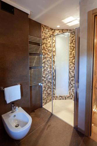 a bathroom with a shower with a sink and a toilet at Asiago Sporting Hotel & Spa in Asiago