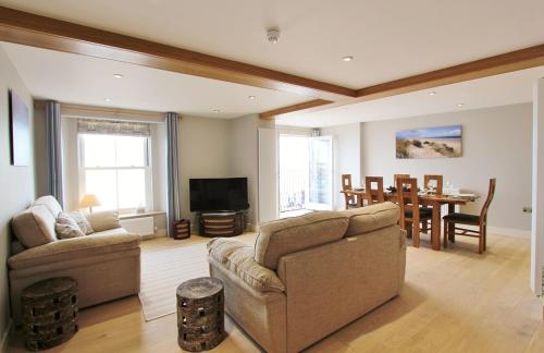 a living room with a couch and a dining room at Goose's Getaway in Wells next the Sea