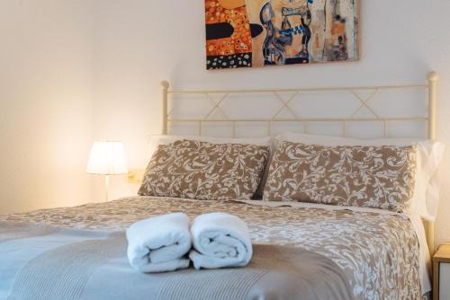 1 dormitorio con 2 toallas en una cama en La Corrala de Triana en Sevilla
