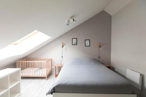 a attic bedroom with a bed and a crib at Au détour des Places in Arras