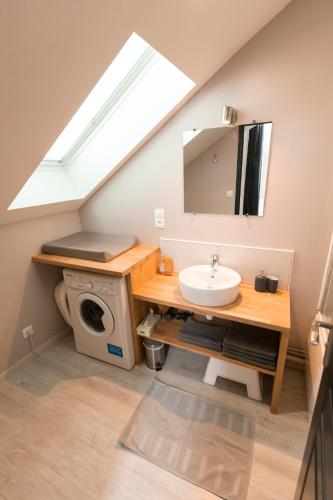 a bathroom with a sink and a washing machine at Au détour des Places in Arras