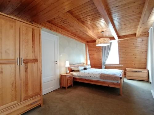 a bedroom with a bed and a wooden ceiling at Dom Lachy Dolne in Brenna