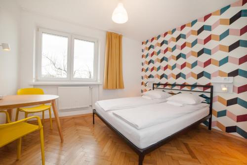 a bedroom with a bed with a geometric wall at Atlantis Hostel in Kraków