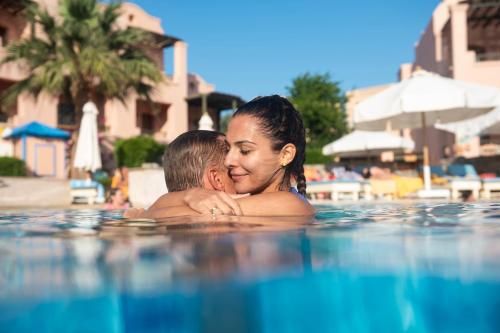 un homme et une femme dans une piscine dans l'établissement Three Corners Rihana Resort El Gouna, à Hurghada