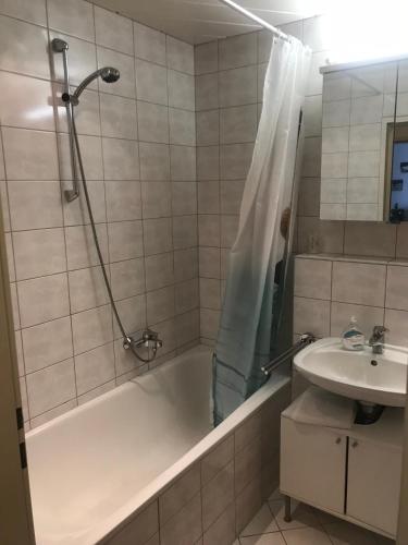 a bathroom with a tub and a sink and a shower at Apartment 3 min walk to Old Town in Innsbruck