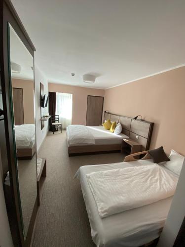a hotel room with two beds and a mirror at Nueva Park in Braşov