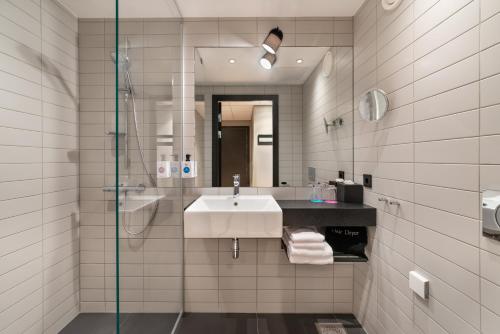 a bathroom with a sink and a glass shower at Quality Hotel River Station in Drammen