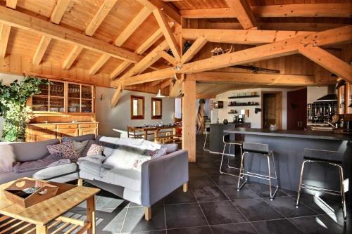 un salon avec un canapé et un bar dans l'établissement CHALET INDIVIDUEL -SAUNA - WIFI- SAINT JEAN D'AULPS - 14 PERSONNES - CHALET COFFY, à Saint-Jean-dʼAulps
