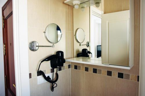 a bathroom with two sinks and two mirrors on the wall at Apartamentos Costa de la Luz playa in Rota