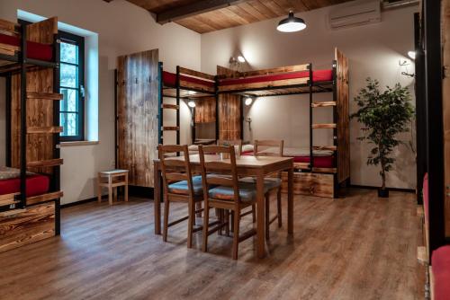 Habitación con mesa, sillas y literas. en Turn Hostel, en Liubliana