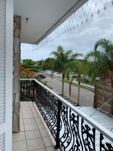 a balcony with a black and white railing and palm trees at Recanto da Sol in Florianópolis
