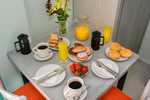 a table with breakfast foods and cups of coffee and juice at Louladakis Apartments in Kolymvari