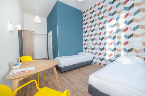 a small room with a bed and a table and chairs at Atlantis Hostel in Kraków