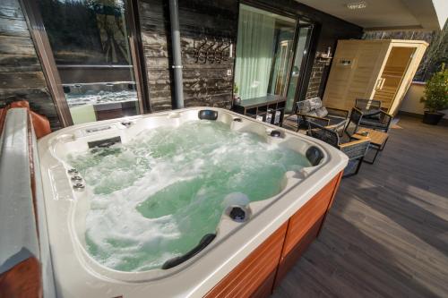 una vasca idromassaggio con acqua verde in una stanza di Mariah Spa Deluxe Apartment in SILVER MOUNTAIN a Poiana Brasov