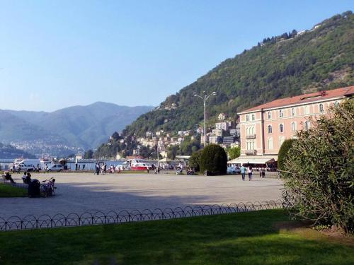 a group of people sitting in a courtyard with a mountain at New Fontana Rooms in Como