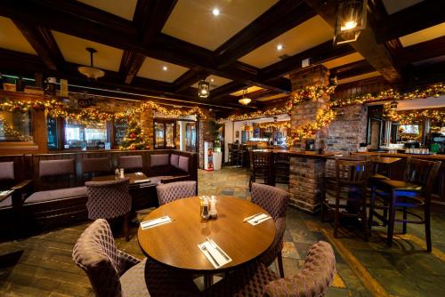 um restaurante com uma mesa e cadeiras de madeira e um bar em White Sands Hotel em Portmarnock