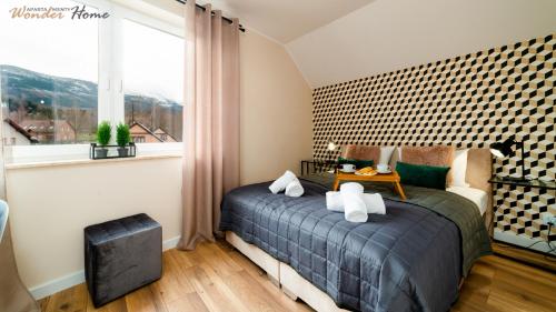 een slaapkamer met een bed en een raam bij Wonder Home - Apartamenty w malowniczej okolicy z balkonami i widokiem na góry in Karpacz