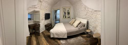 1 dormitorio con cama y pared de piedra en Panta Rei en Ostuni