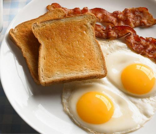 een bord met twee eieren, toast en spek bij Millgate Midlands Retreat in Balgowan