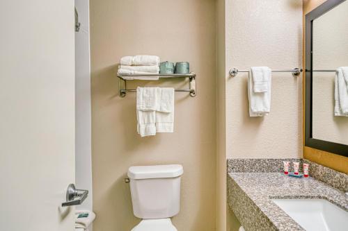 a bathroom with a toilet and a sink with towels at Trident Inn & Suites New Orleans in New Orleans