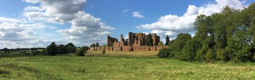 an old castle in a field on a cloudy day at The Old Bakery in Kenilworth